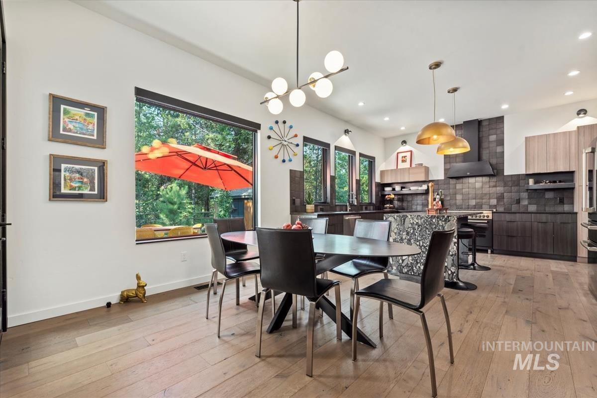 Dining room with light wood-style floors, recessed lighting, and a chandelier