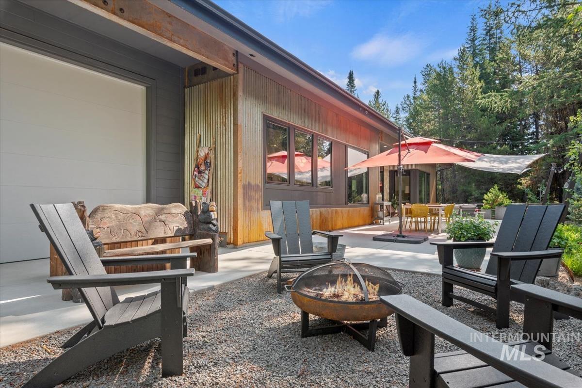 View of patio / terrace with a fire pit, a garage, and outdoor dining area