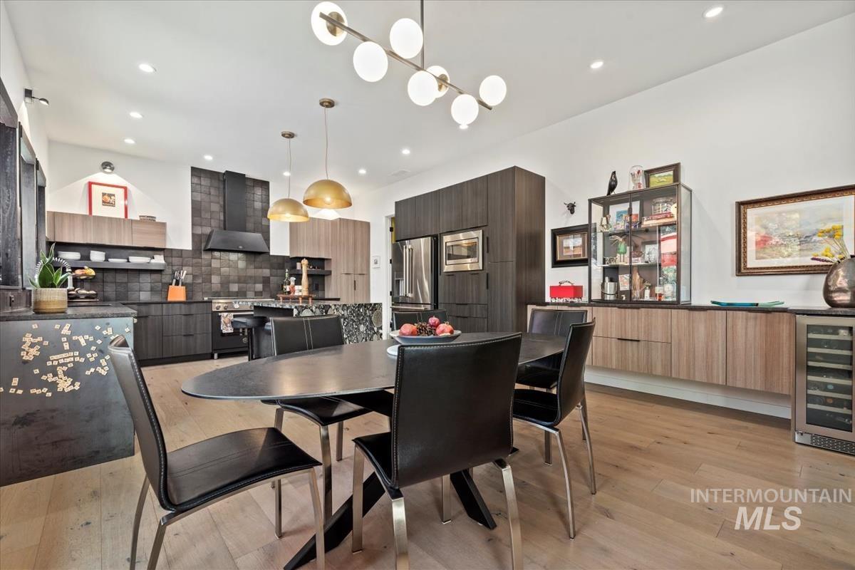 Dining area with wine cooler, recessed lighting, and light wood-style flooring