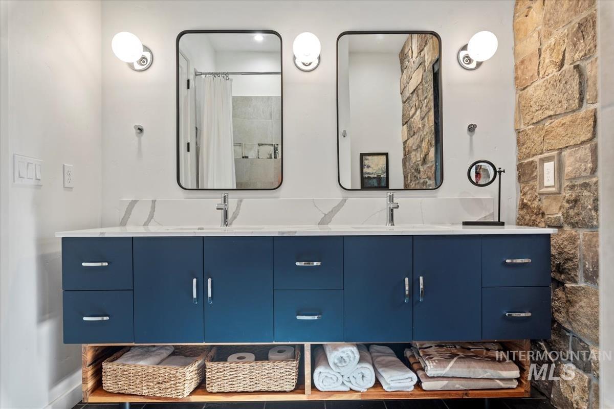Bathroom featuring double vanity and curtained shower