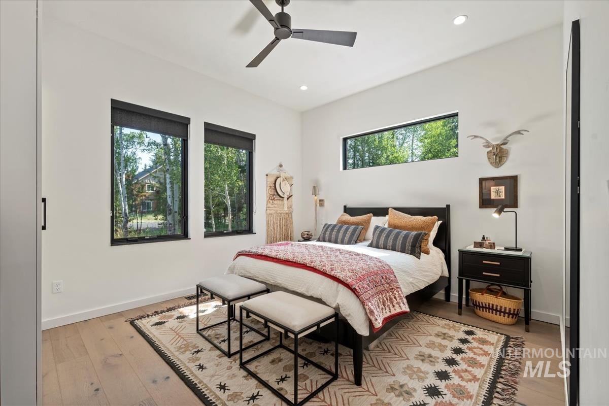 Bedroom with light wood finished floors, recessed lighting, and a ceiling fan