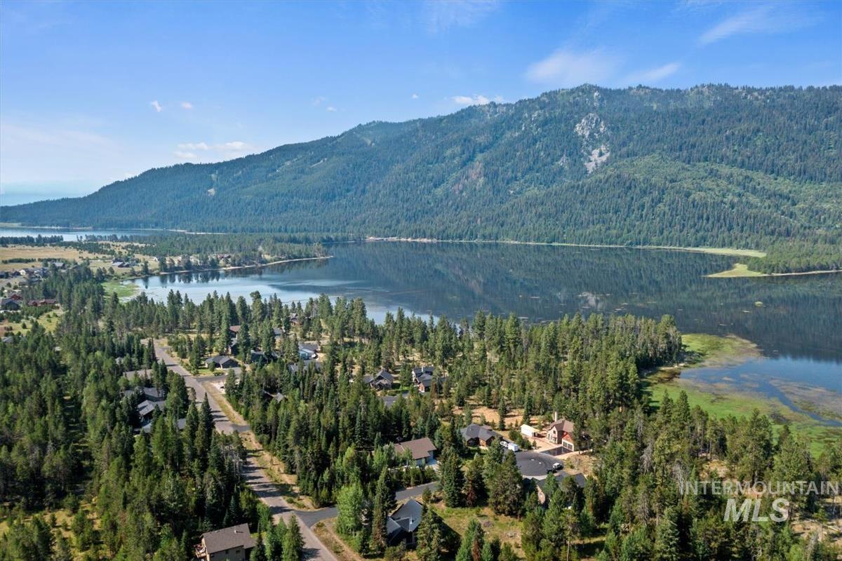 View of mountain backdrop with a large body of water and a heavily wooded area