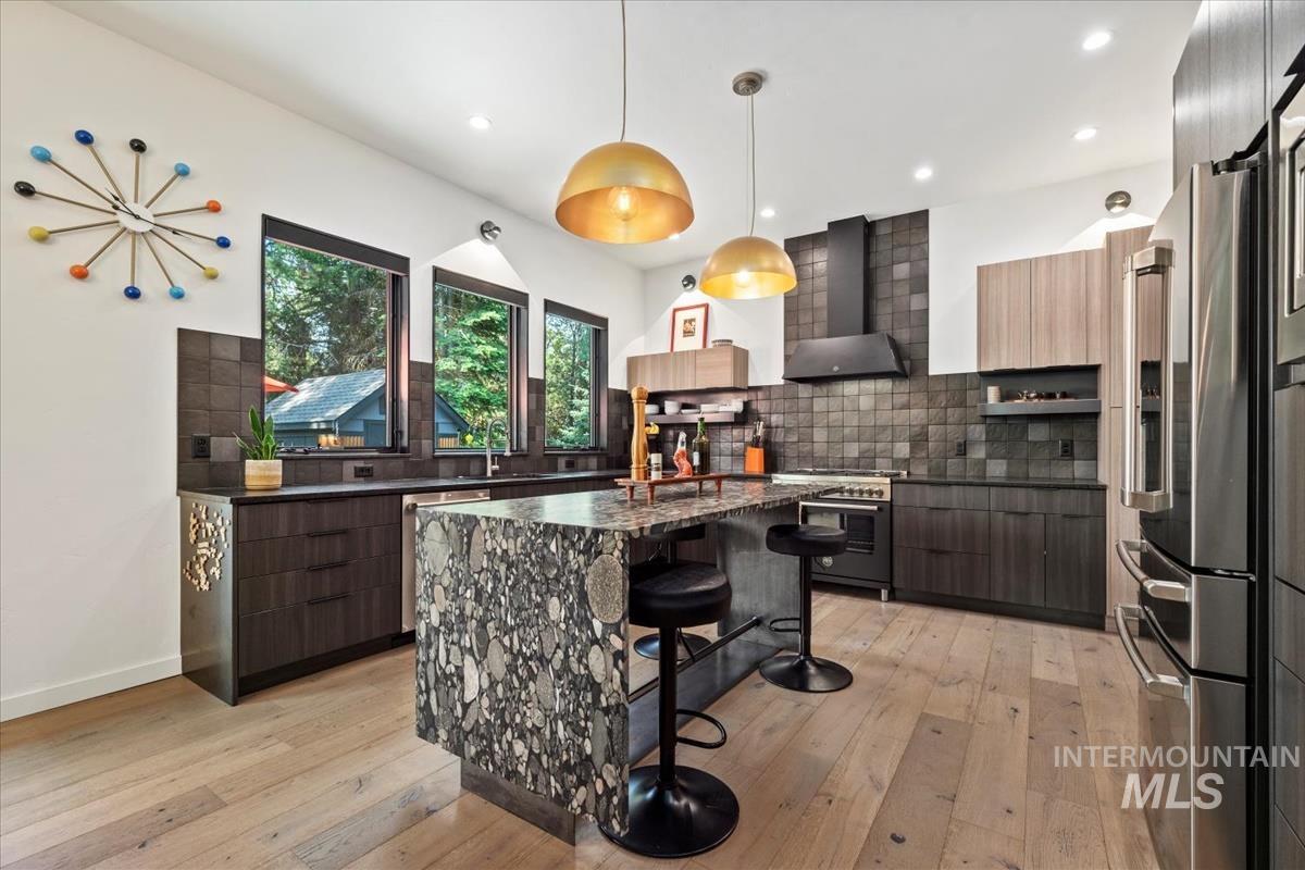 Kitchen with modern cabinets, light wood-style floors, a breakfast bar, and recessed lighting