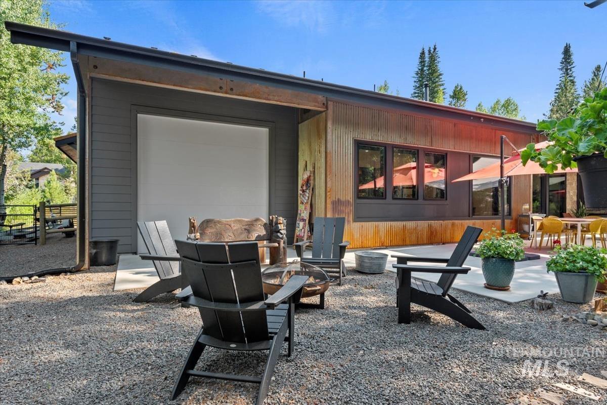 View of patio with an outdoor fire pit and an attached garage