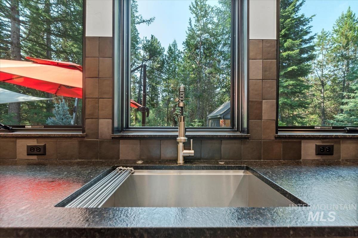Kitchen view of a sink and dark countertops