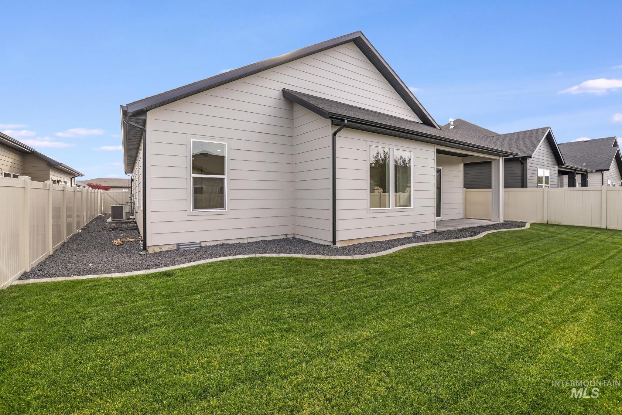 Rear view of house with a fenced backyard and a patio