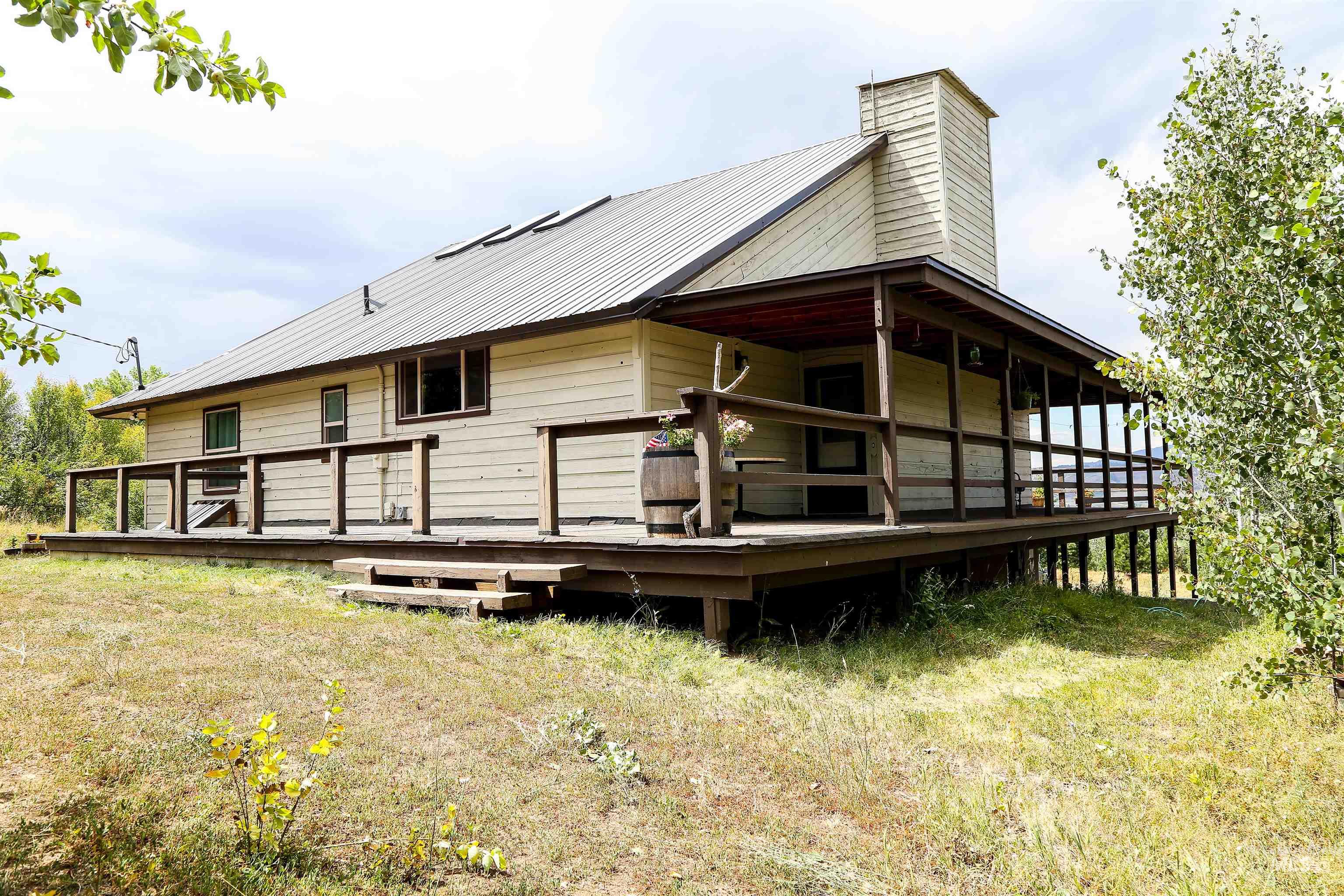 View of home's exterior featuring a metal roof, a chimney, and a wooden deck