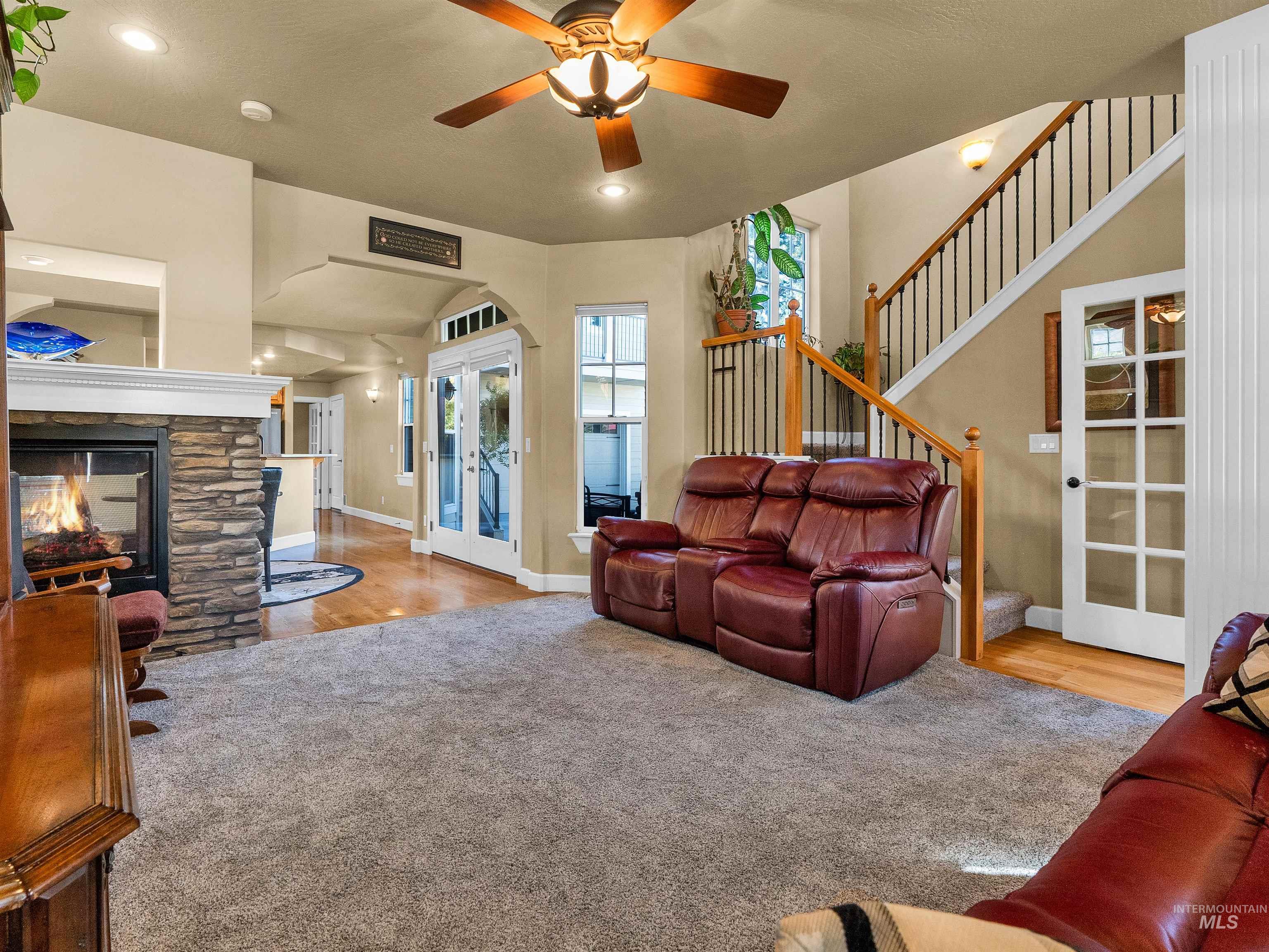 Living room featuring a fireplace, light colored carpet, stairs, and recessed lighting