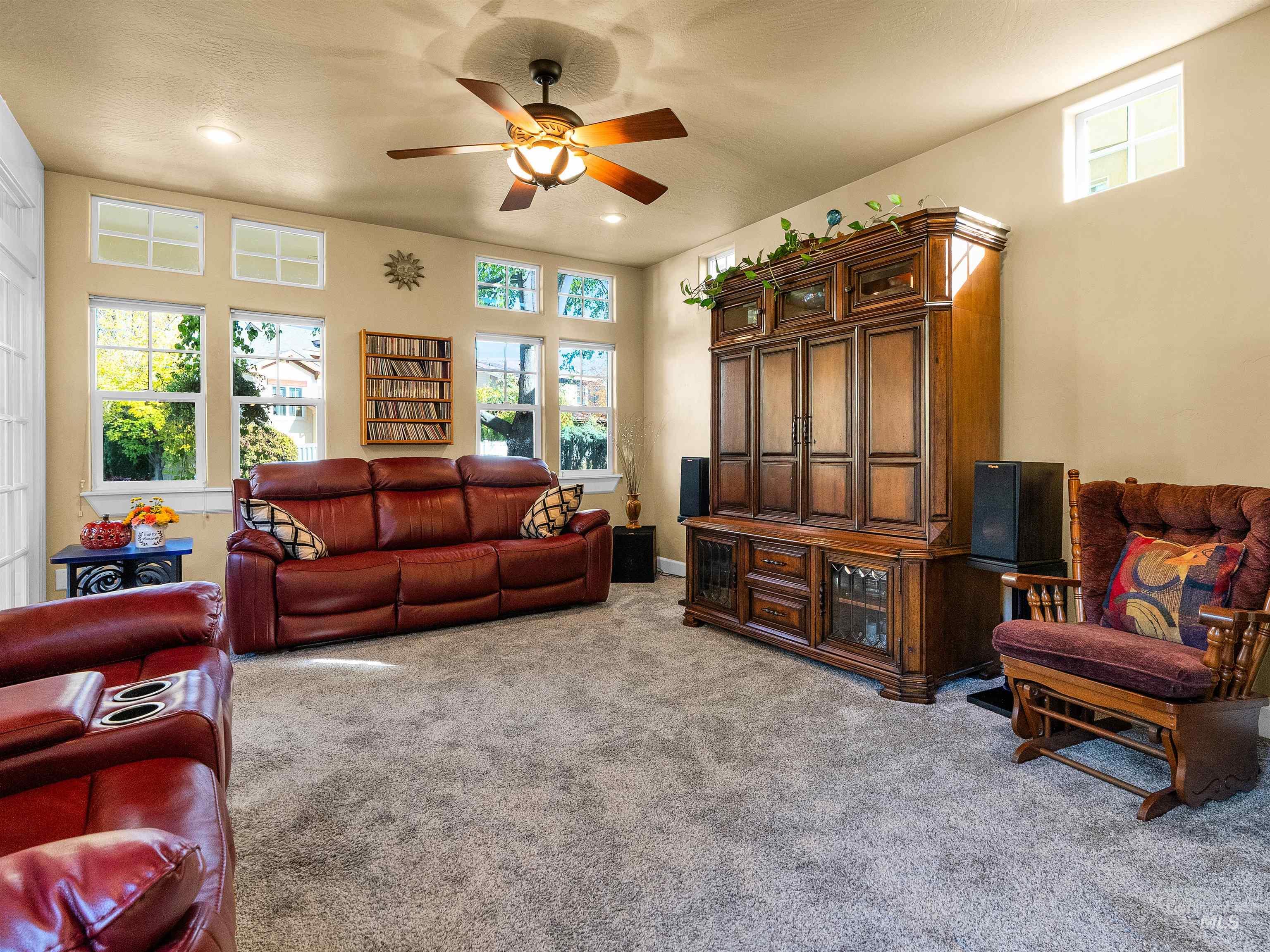 Living room featuring healthy amount of natural light, light carpet, and ceiling fan