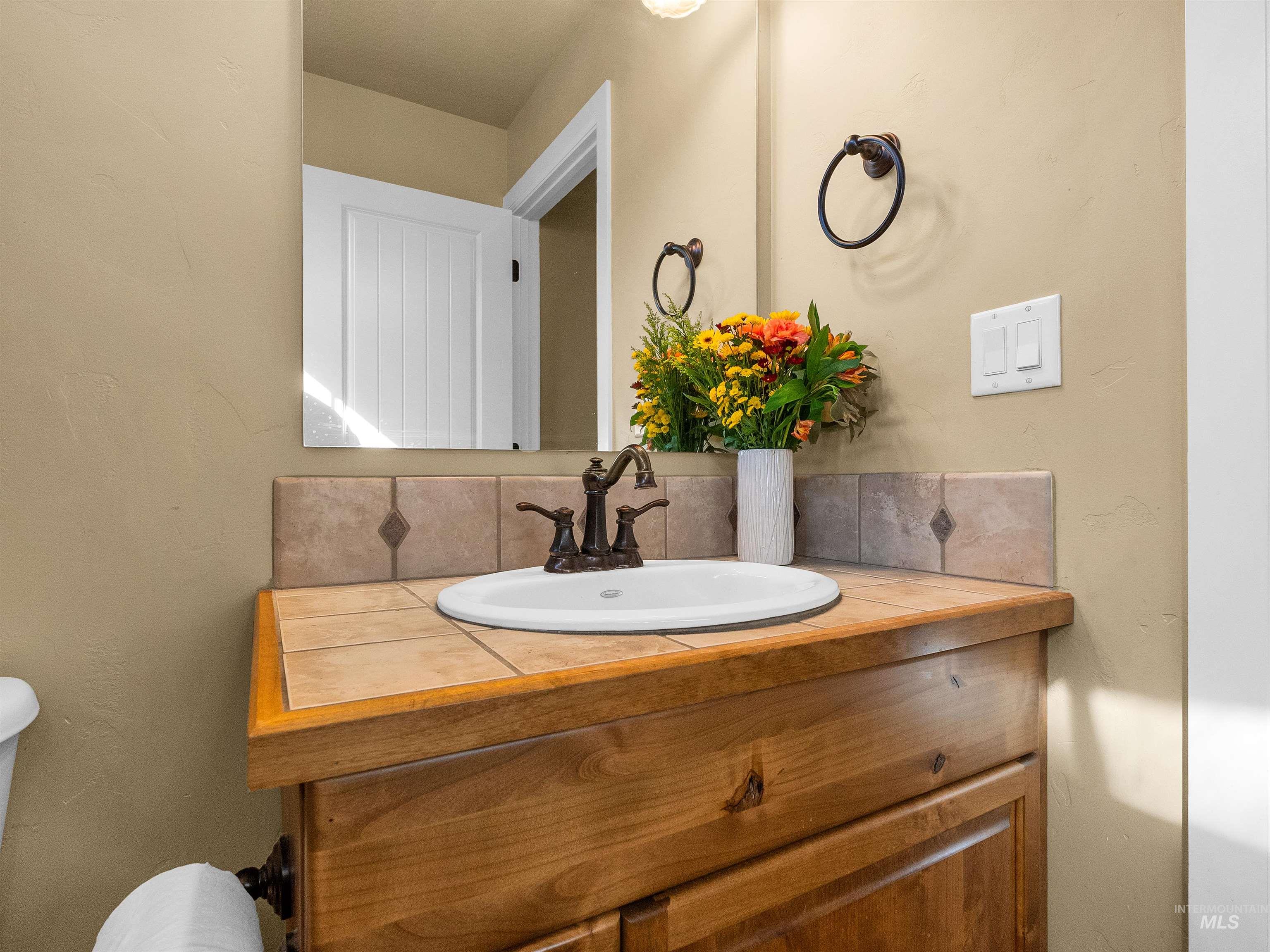 Bathroom with vanity and tasteful backsplash