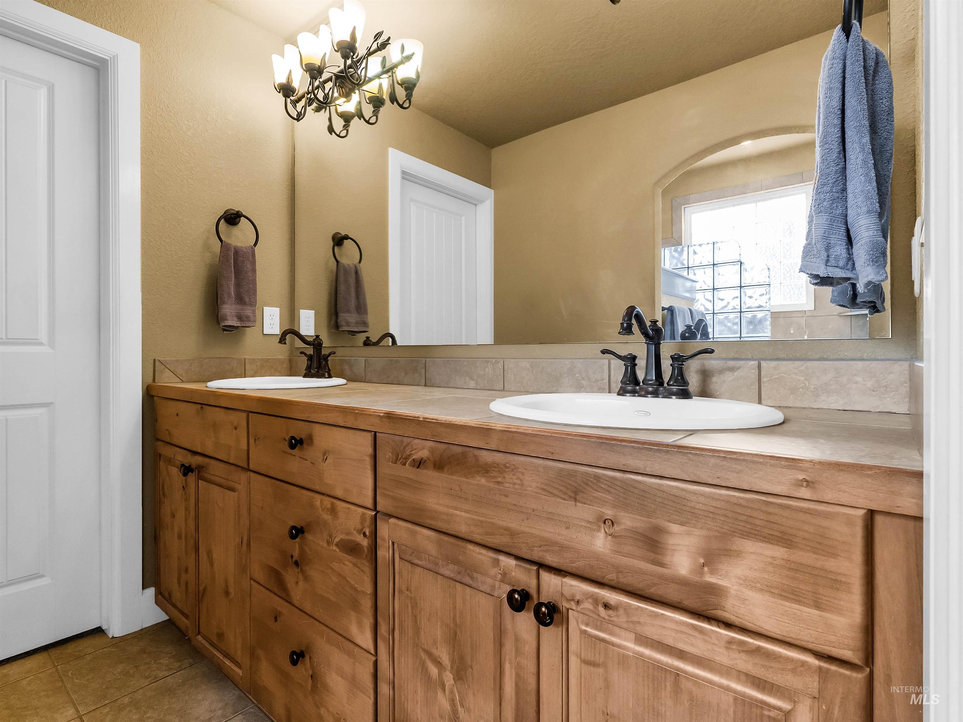 Bathroom with double vanity and light tile patterned floors