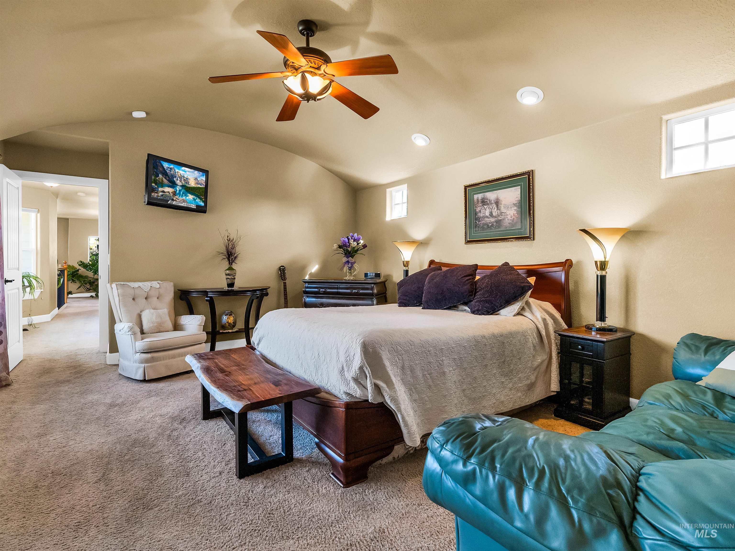 Carpeted bedroom featuring lofted ceiling, a ceiling fan, and recessed lighting