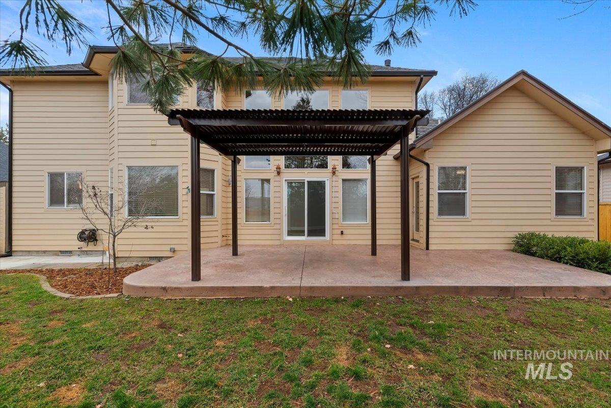 Back of property featuring a pergola, a yard, and a patio