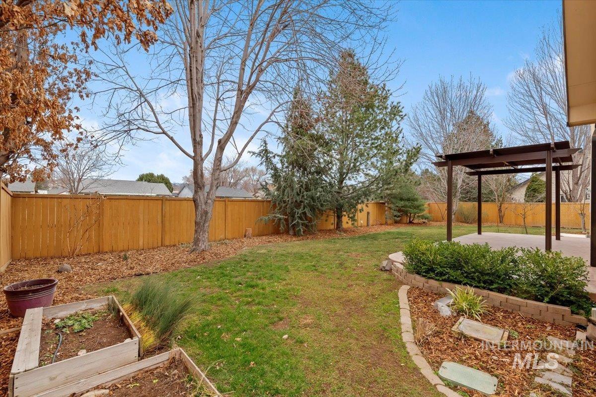Fenced backyard with a garden and a patio area
