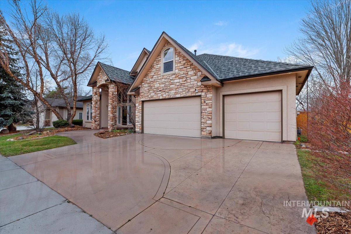 Craftsman house featuring concrete driveway, an attached garage, and stone siding