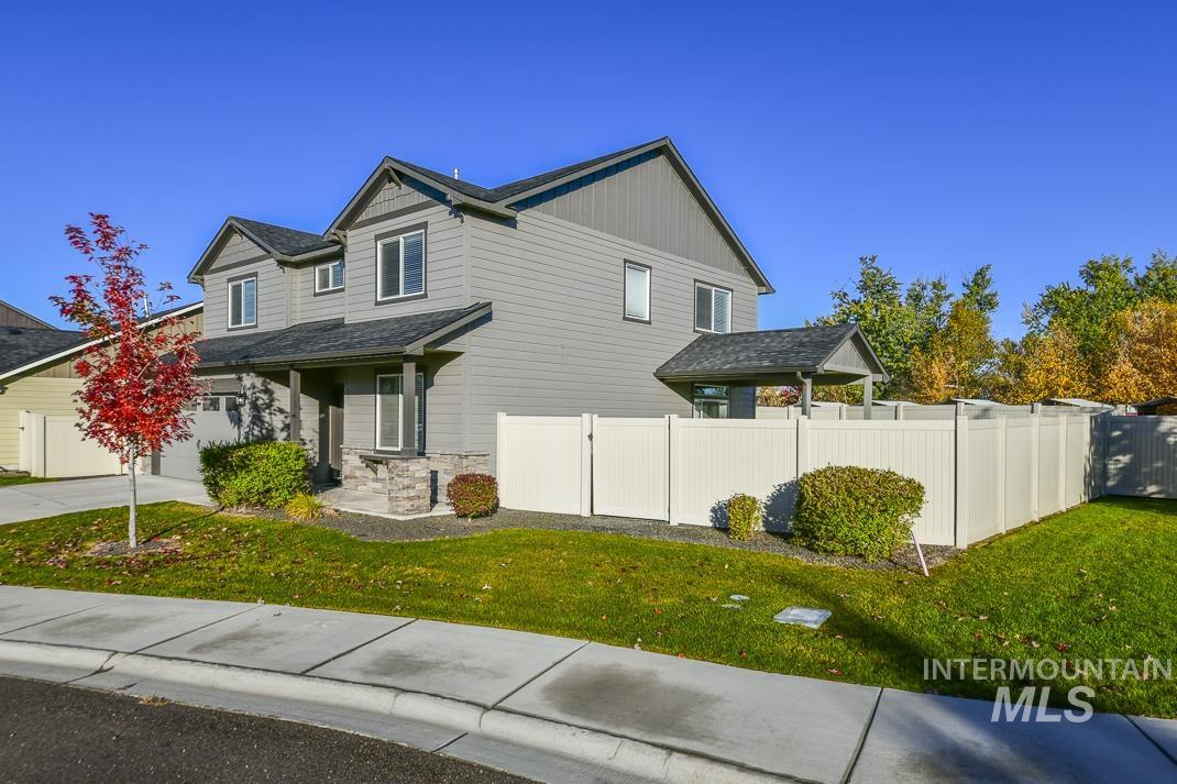 View of home's exterior with stone siding, a garage, driveway, and board and batten siding