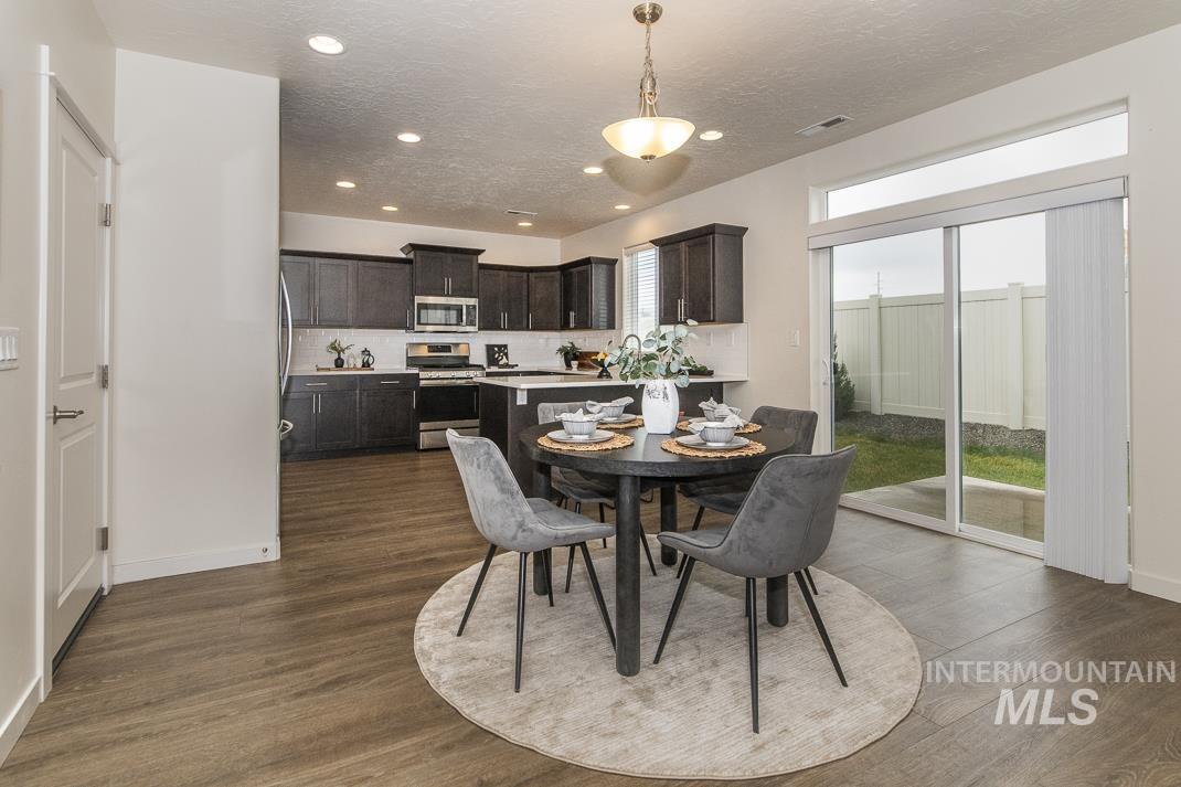 Dining area with a textured ceiling, dark wood finished floors, and recessed lighting