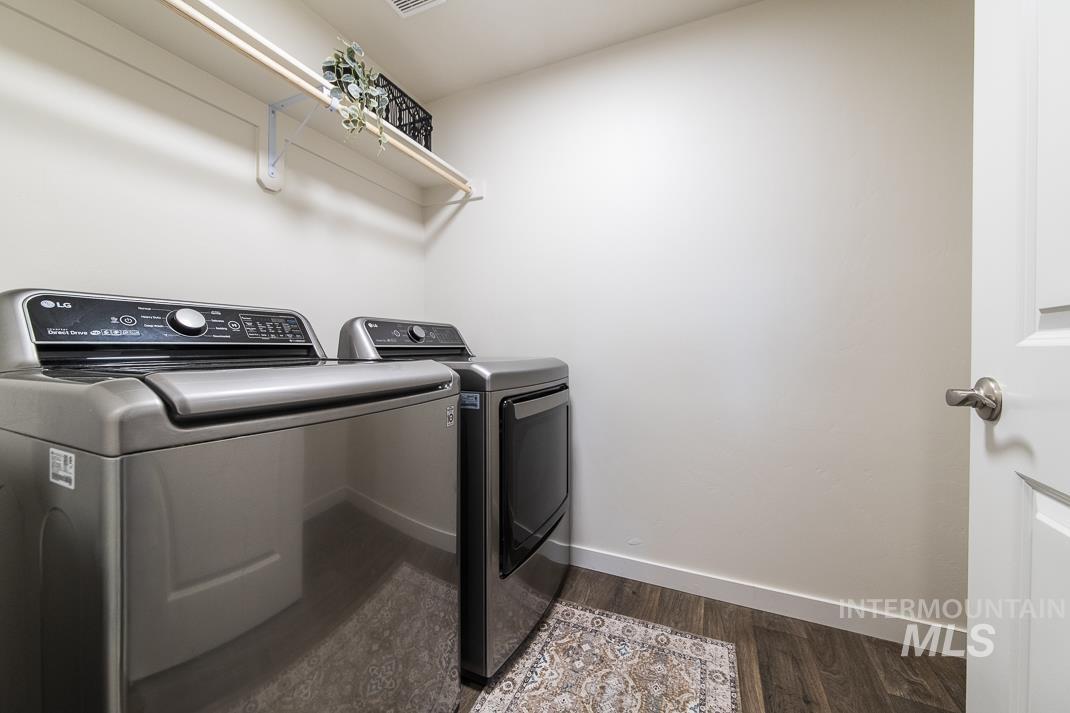 Washroom featuring washing machine and dryer and dark wood-style flooring