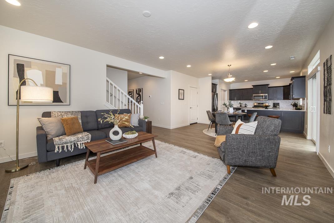 Living room featuring recessed lighting, stairs, wood finished floors, and a textured ceiling