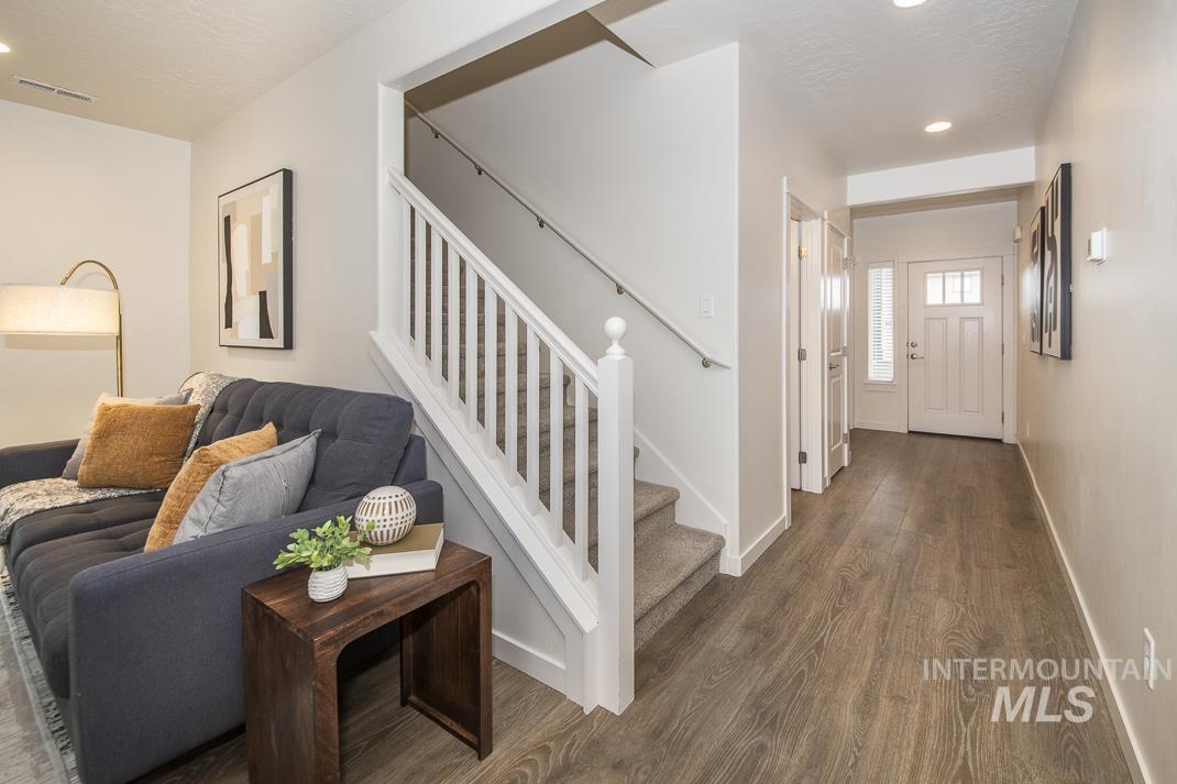 Living room with stairs, recessed lighting, wood finished floors, and a textured ceiling