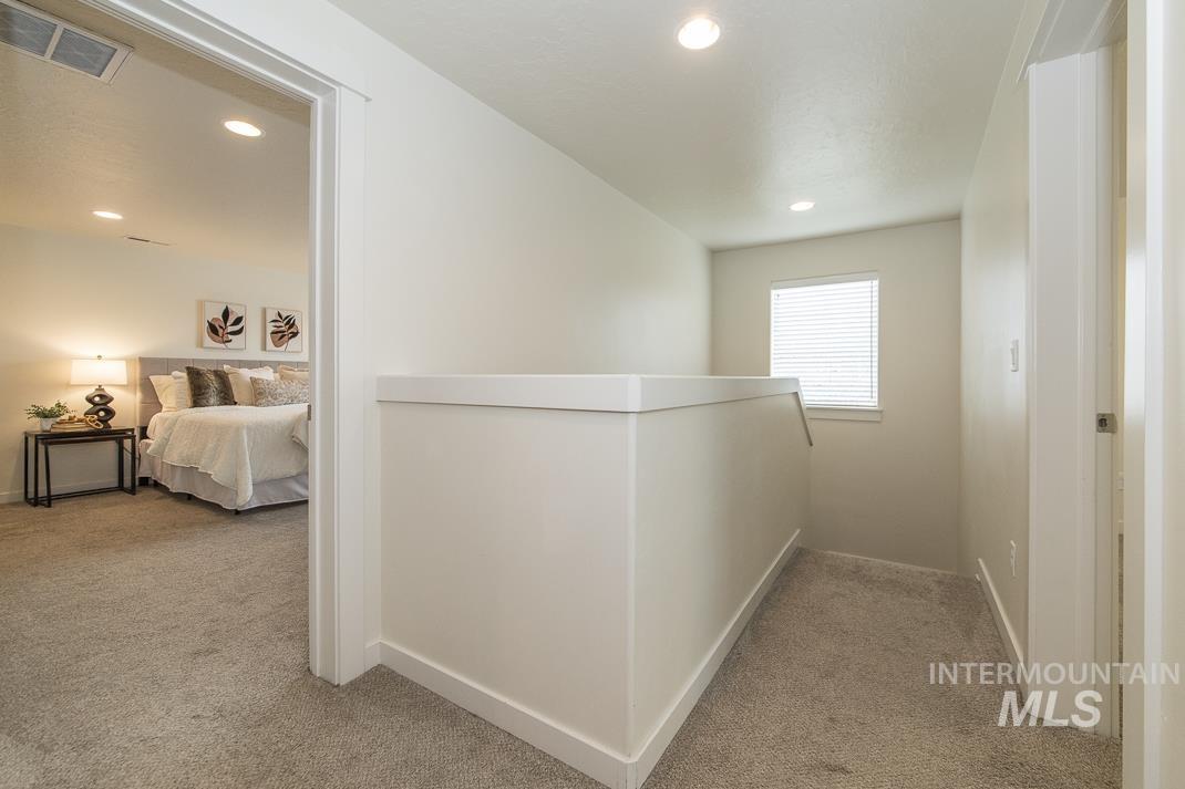 Hall featuring light colored carpet, an upstairs landing, and recessed lighting