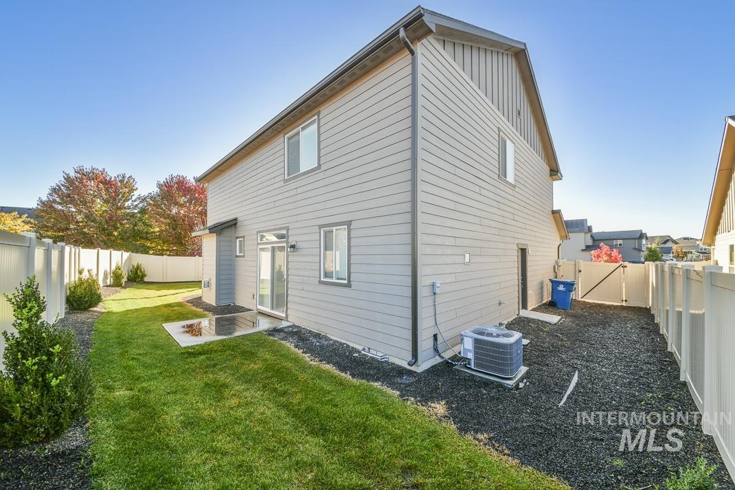 Back of house with a fenced backyard, a patio, and board and batten siding
