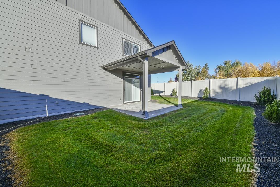 Back of house featuring a fenced backyard, a patio, and board and batten siding