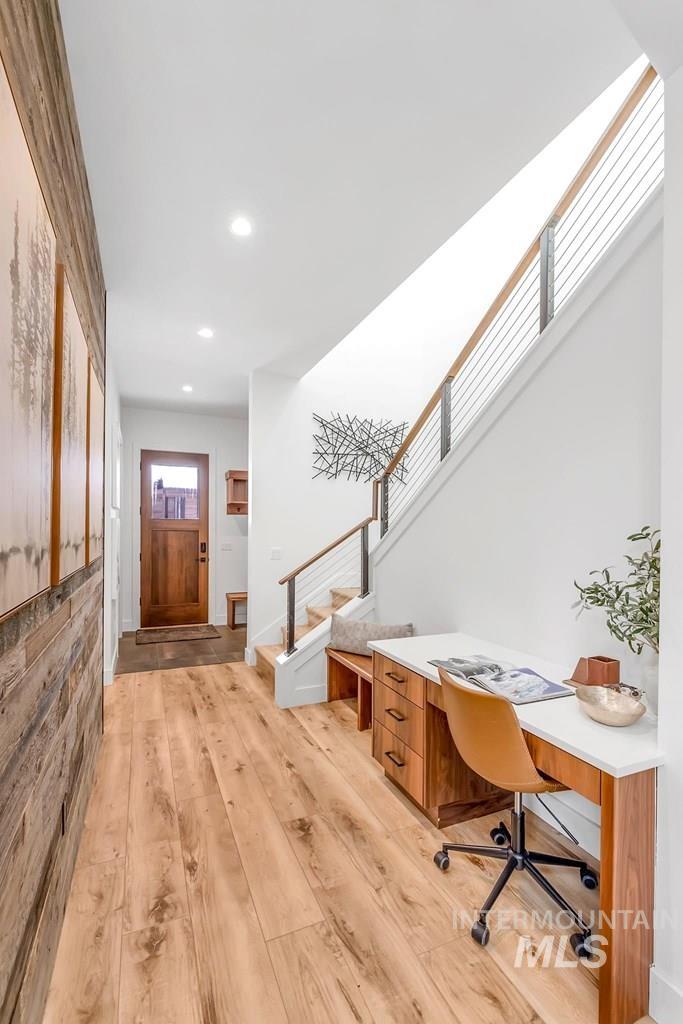 Office area with light wood-style floors and recessed lighting