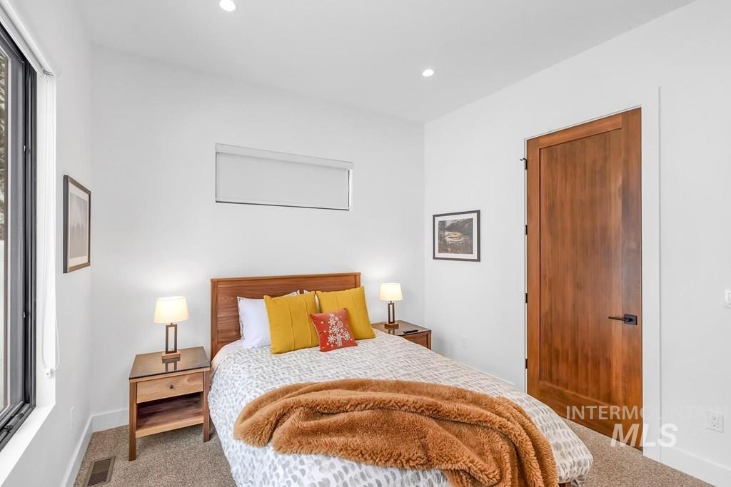Carpeted bedroom with recessed lighting and baseboards