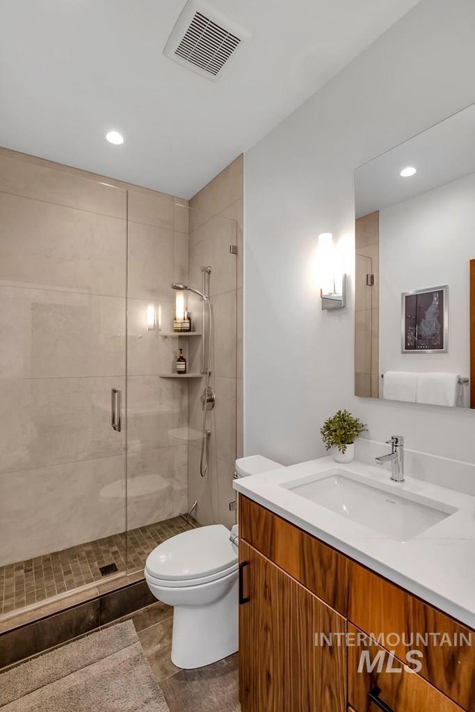 Full bathroom with vanity, a shower stall, and recessed lighting