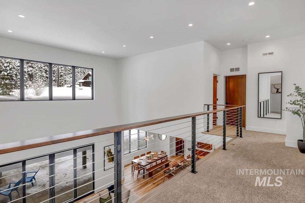 Hallway with recessed lighting, carpet floors, and an upstairs landing