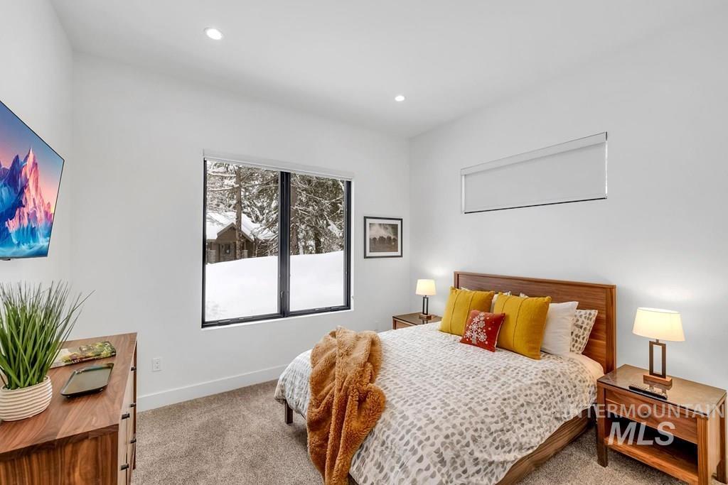 Carpeted bedroom with baseboards and recessed lighting