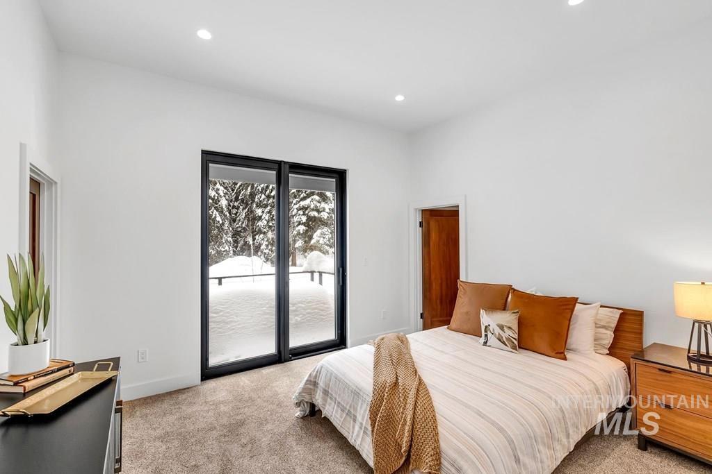 Bedroom with access to exterior, light colored carpet, and recessed lighting