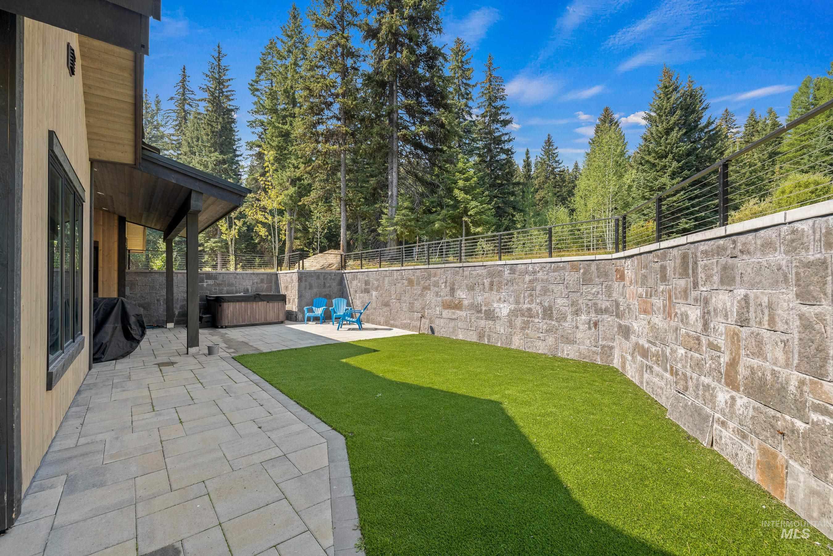 Fenced backyard with a hot tub and a patio area