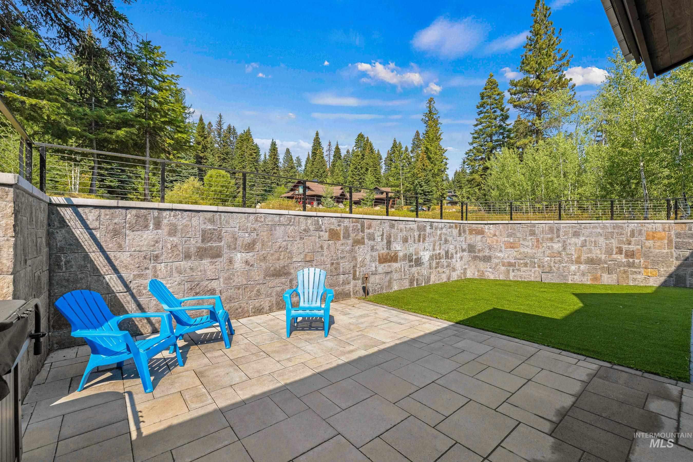 Fenced backyard with a patio and view of wooded area