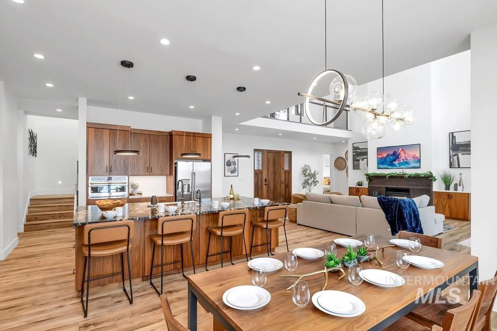 Dining room with light wood finished floors, a chandelier, and recessed lighting