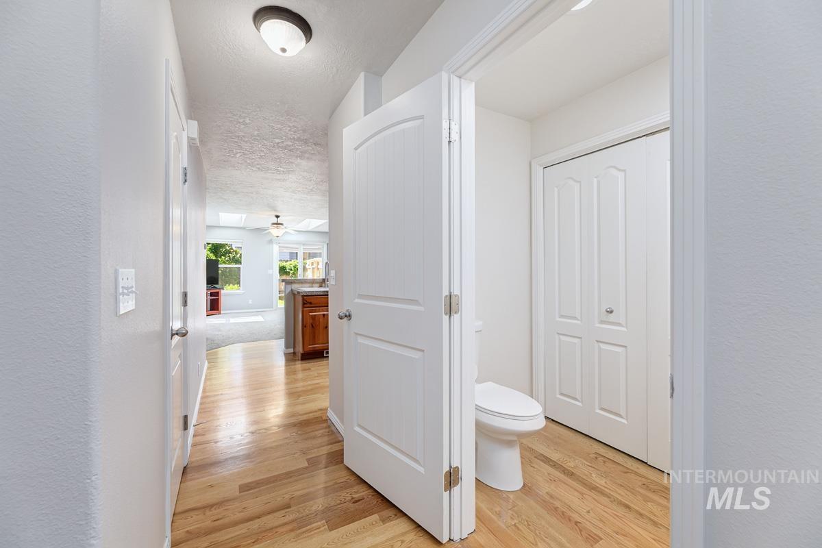 Corridor featuring light wood-type flooring and a textured ceiling