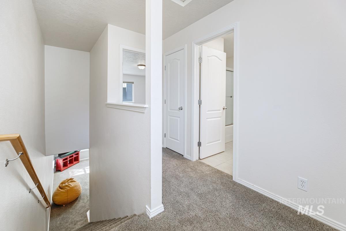 Hallway with carpet floors and baseboards
