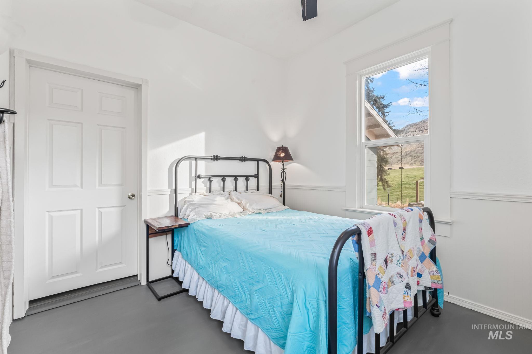Bedroom featuring ceiling fan and concrete floors