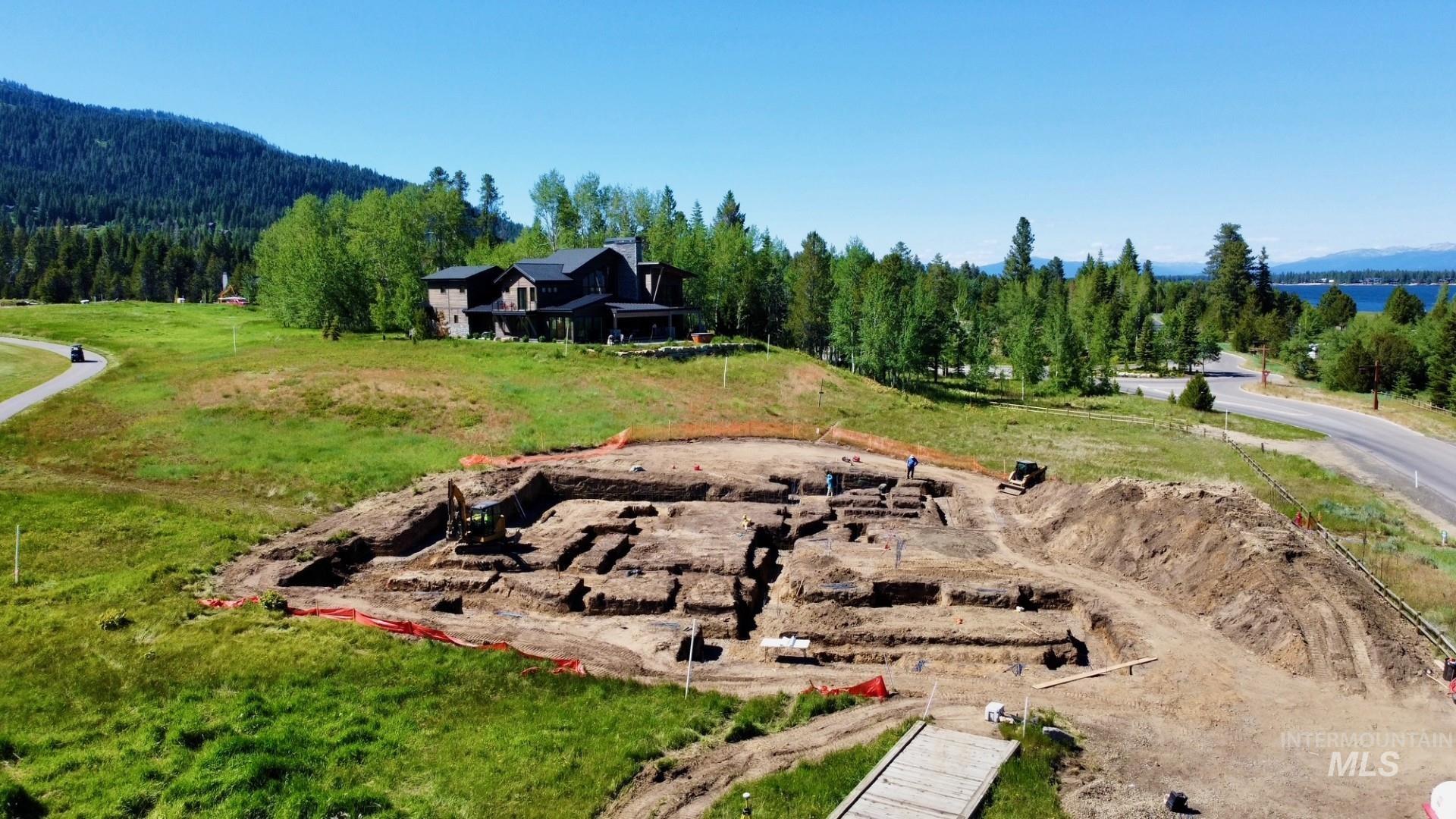 Expansive property featuring a cleared building site, surrounding green space, and distant water views