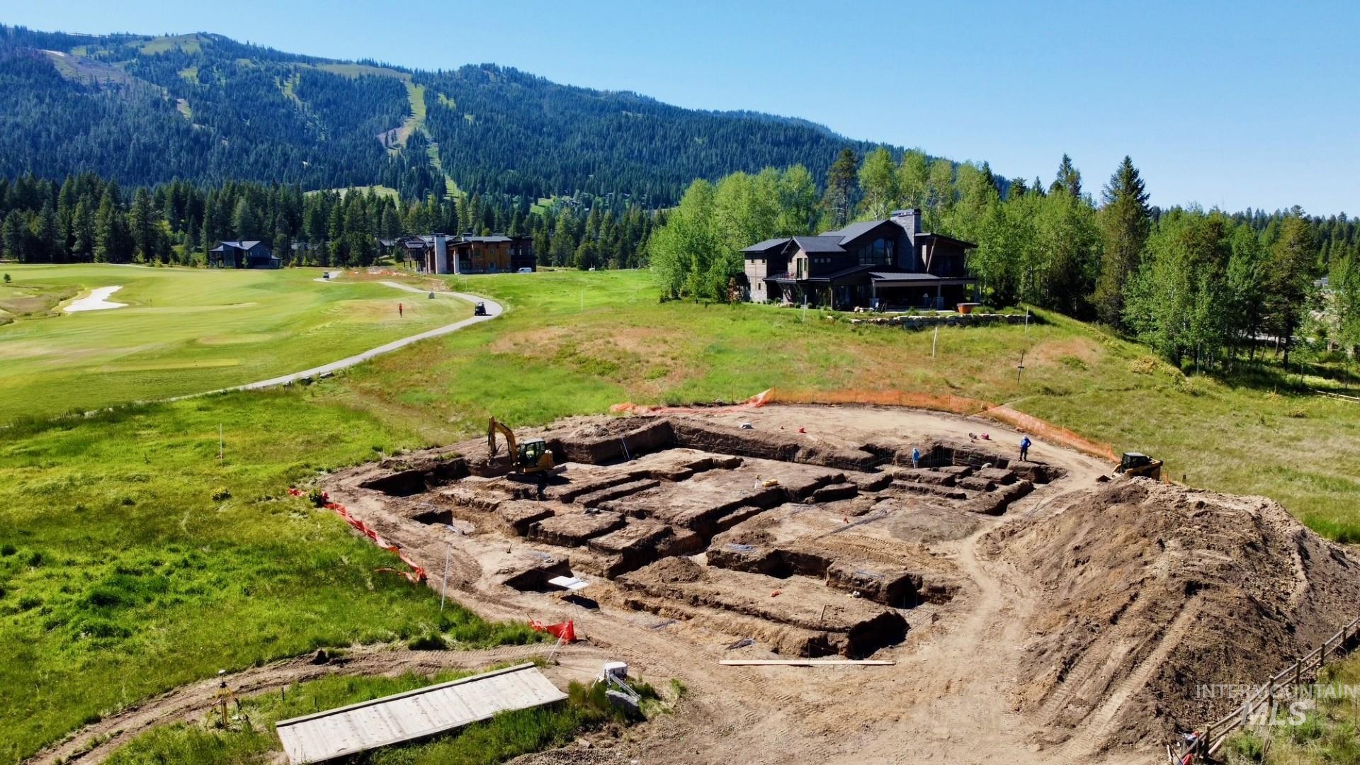 Foundation excavation underway on a spacious lot featuring substantial earthwork
