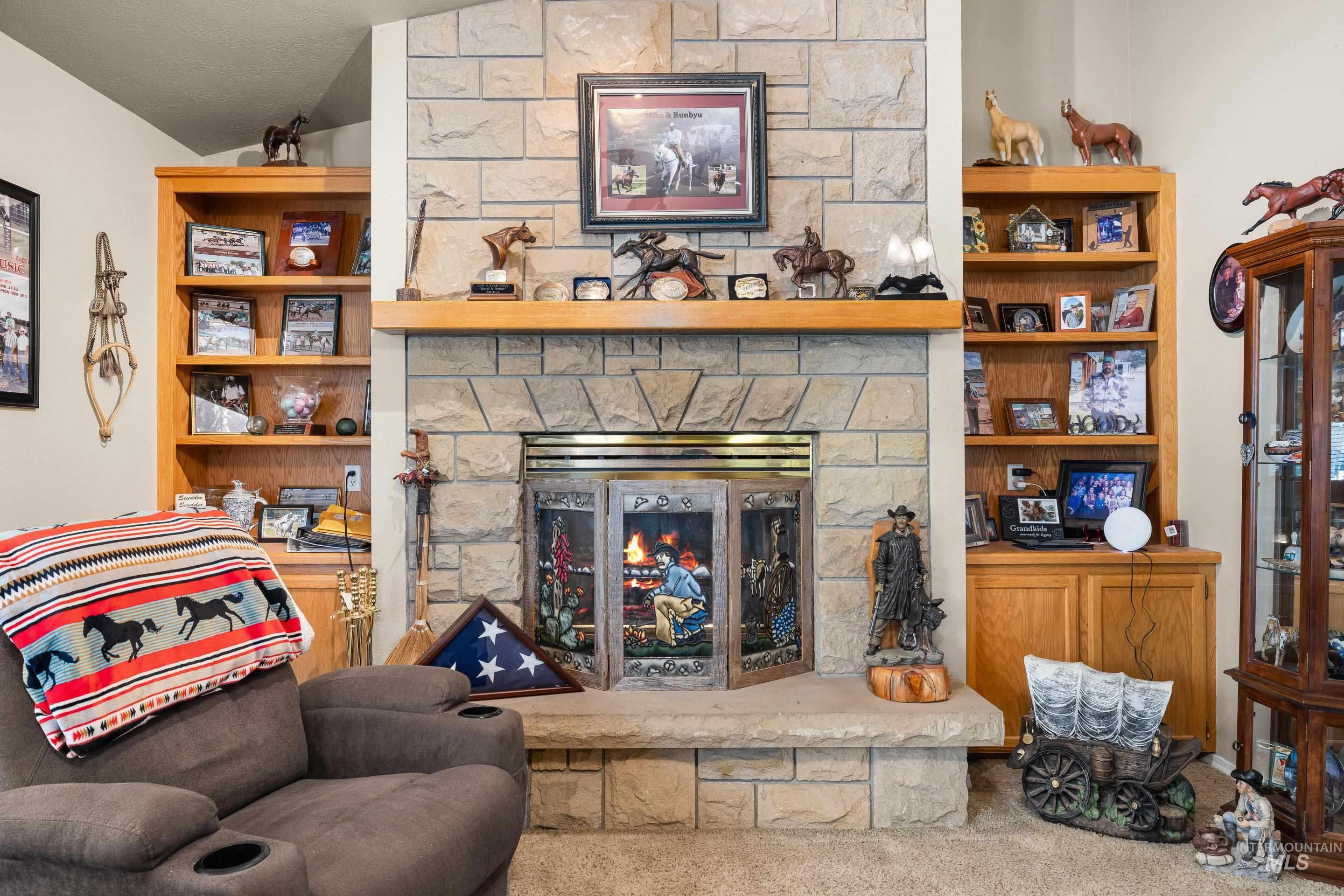 Living room with a fireplace, carpet flooring, and vaulted ceiling