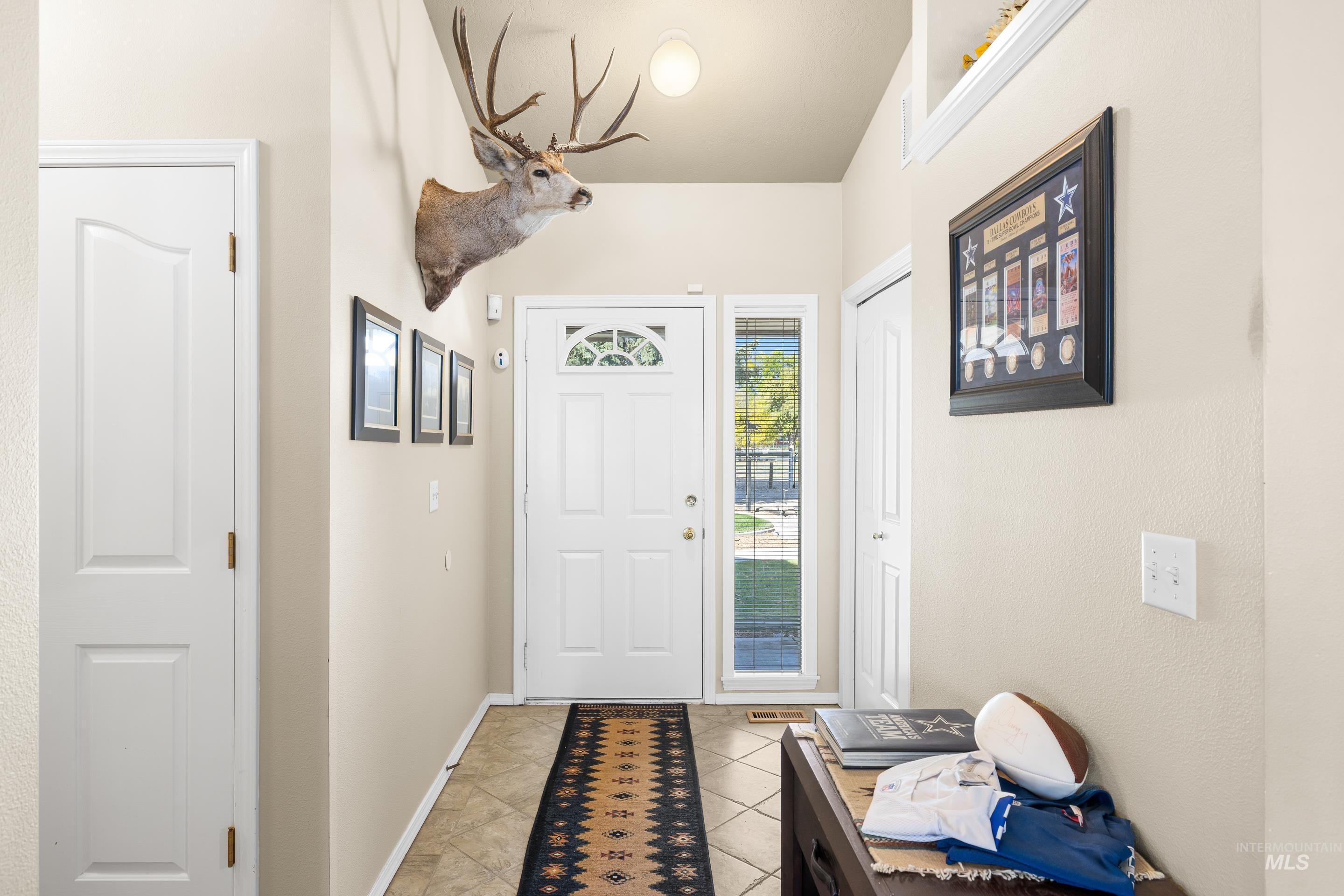Entrance foyer with light tile patterned flooring and baseboards