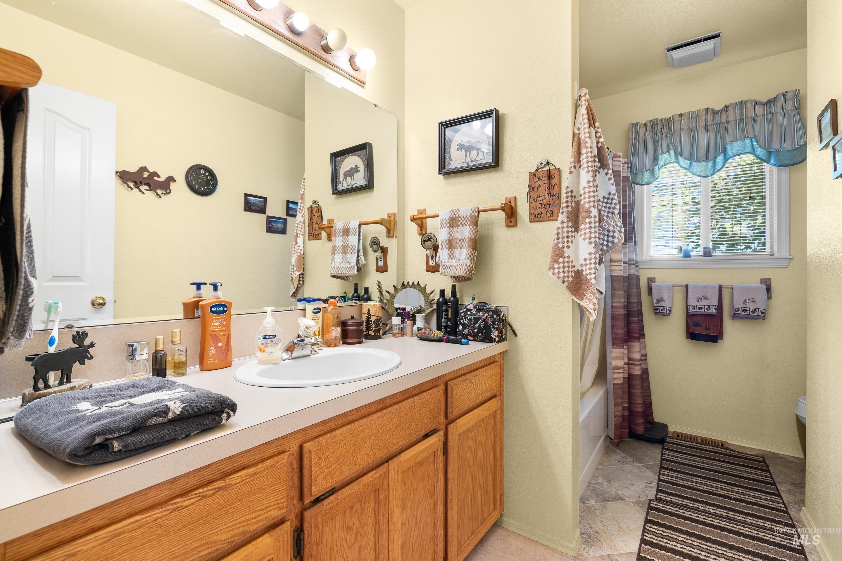 Full bathroom with shower / tub combo with curtain and vanity