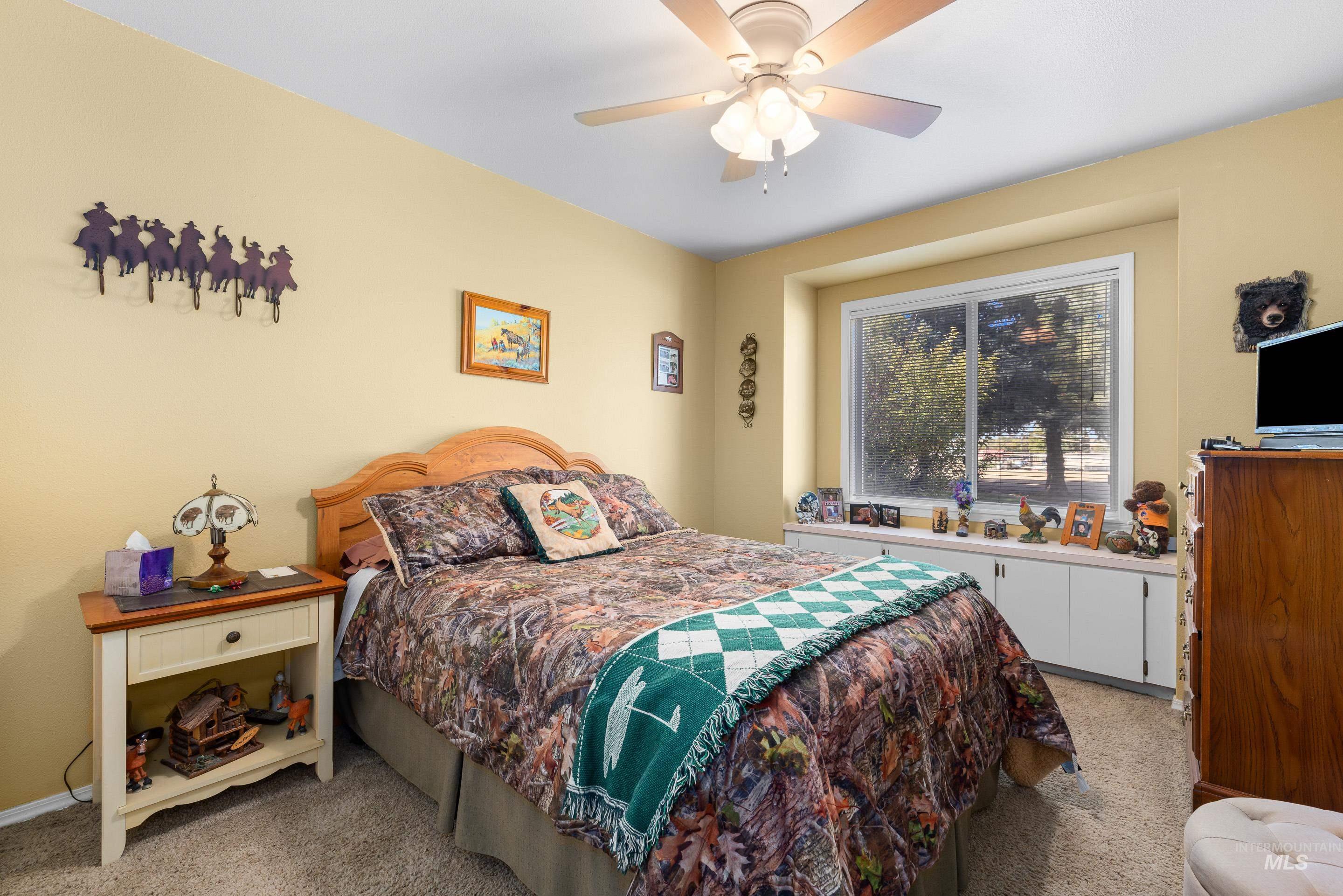 Bedroom with light carpet and a ceiling fan