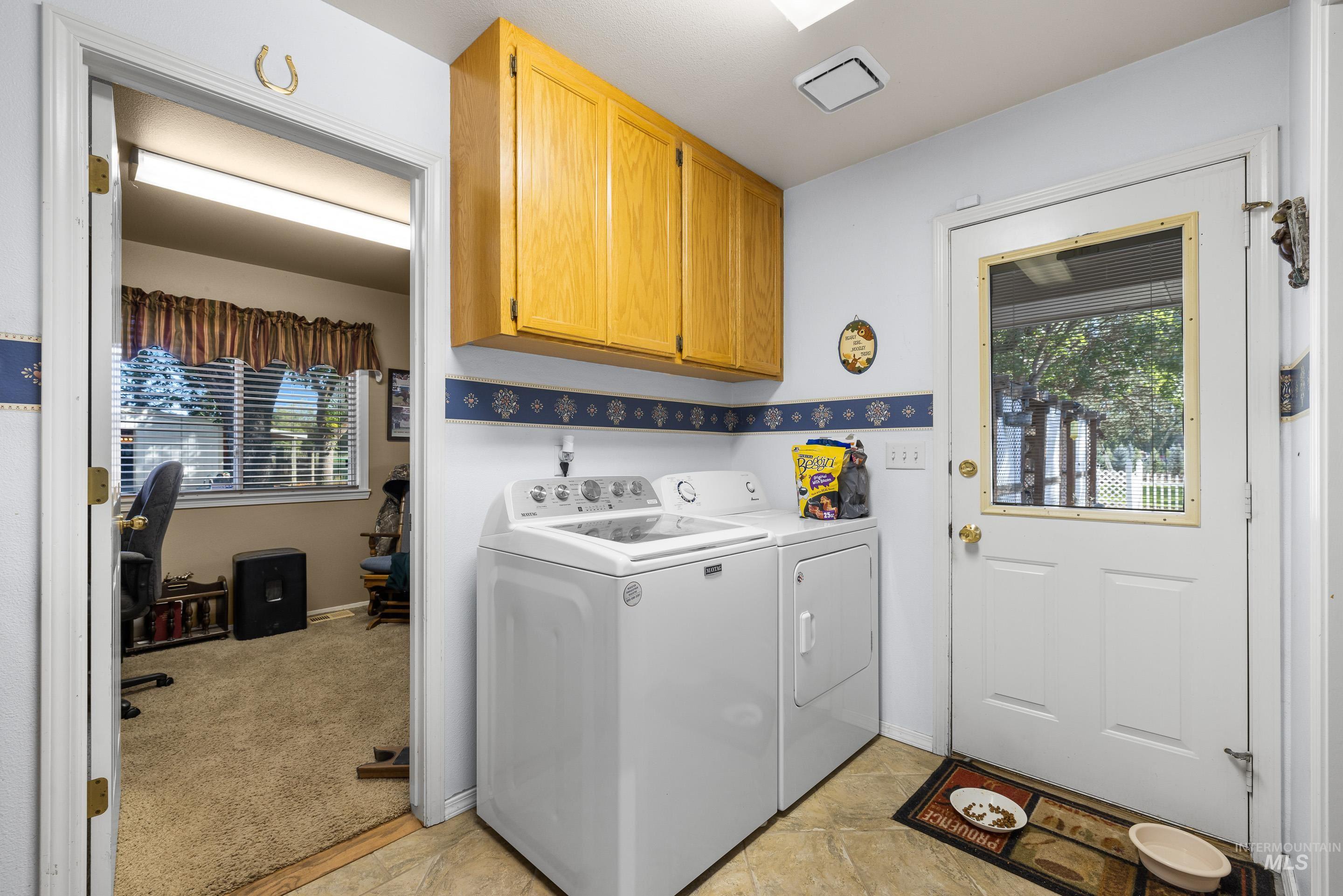 Laundry room featuring cabinet space, washing machine and dryer, and light colored carpet