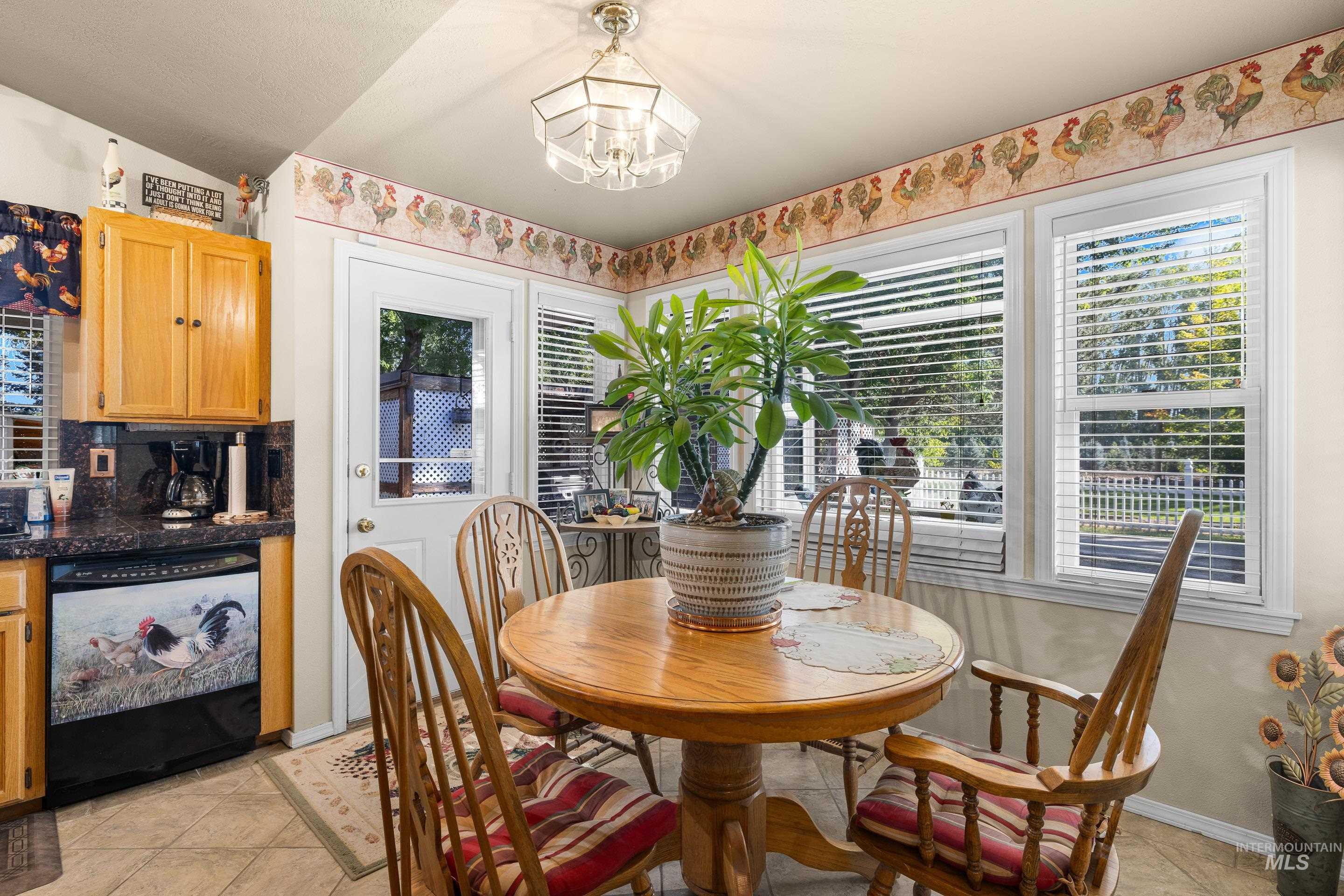 Dining space featuring light tile patterned floors, a chandelier, and vaulted ceiling