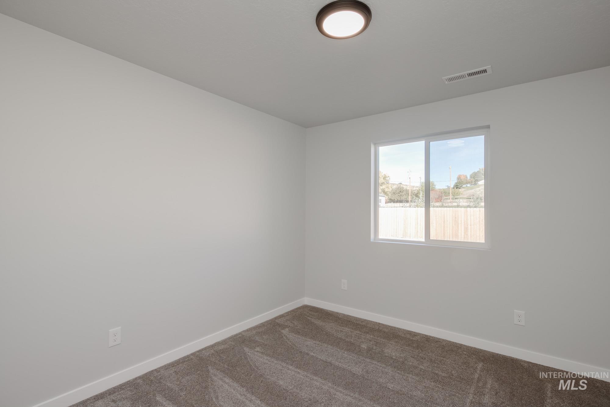 Carpeted empty room featuring baseboards