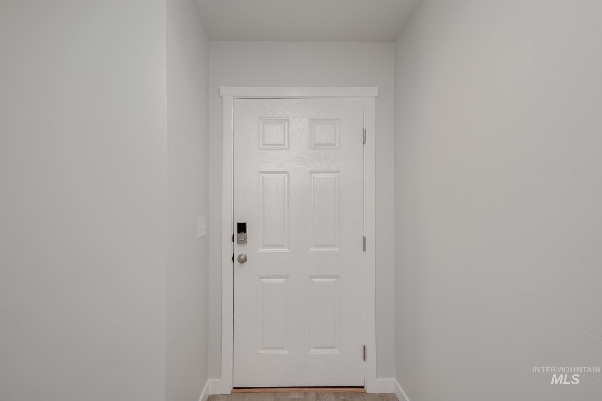Doorway with baseboards and wood finished floors