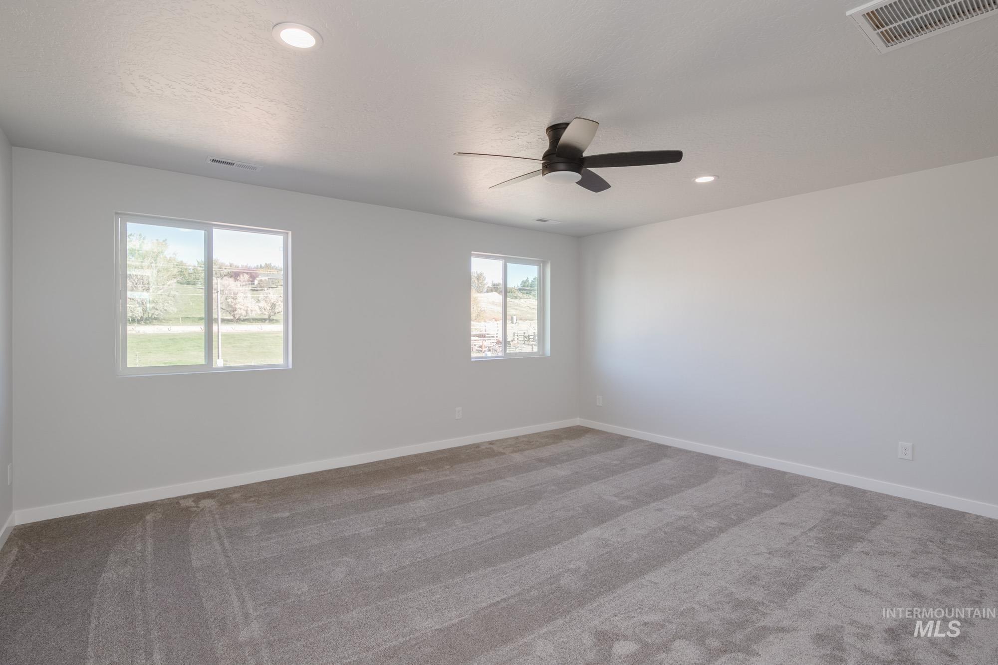 Carpeted spare room with ceiling fan and recessed lighting